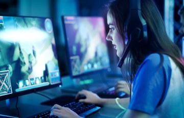 Nuori nainen pelaa counter-strikea tietokoneella