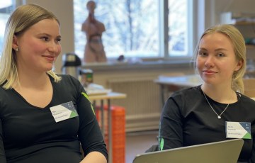 Taitaja-semifinalistit 2022 Sini Vihavainen (vas.) ja Jenna Vuorisalo istuvat luokassa tietokoneen äärellä.