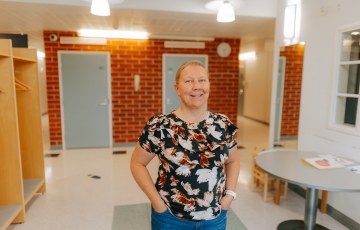Hymyilevä nainen työpaikkansa aulatilassa