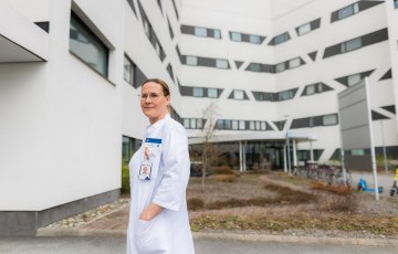 Valkotakkinen lääkäri ulkona sairaalarakennuksen sisäpihalla