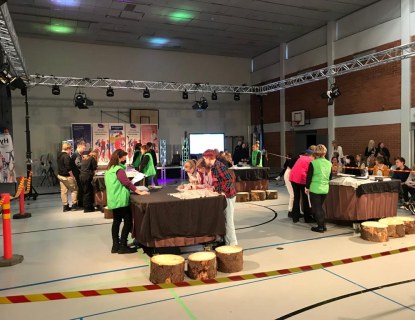 Joukkueita kisaamassa liikuntasalissa omilla työskentelypisteillään