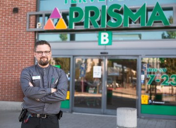 Valokuvassa on Prisman myymäläpäällikkö Anssi Vilen. Anssi seisoo Prisman edessä ja hymyilee. Hänellä on päällään Prisman työasu. 