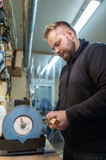 Mies hioo veitsen terää hiomakoneella
